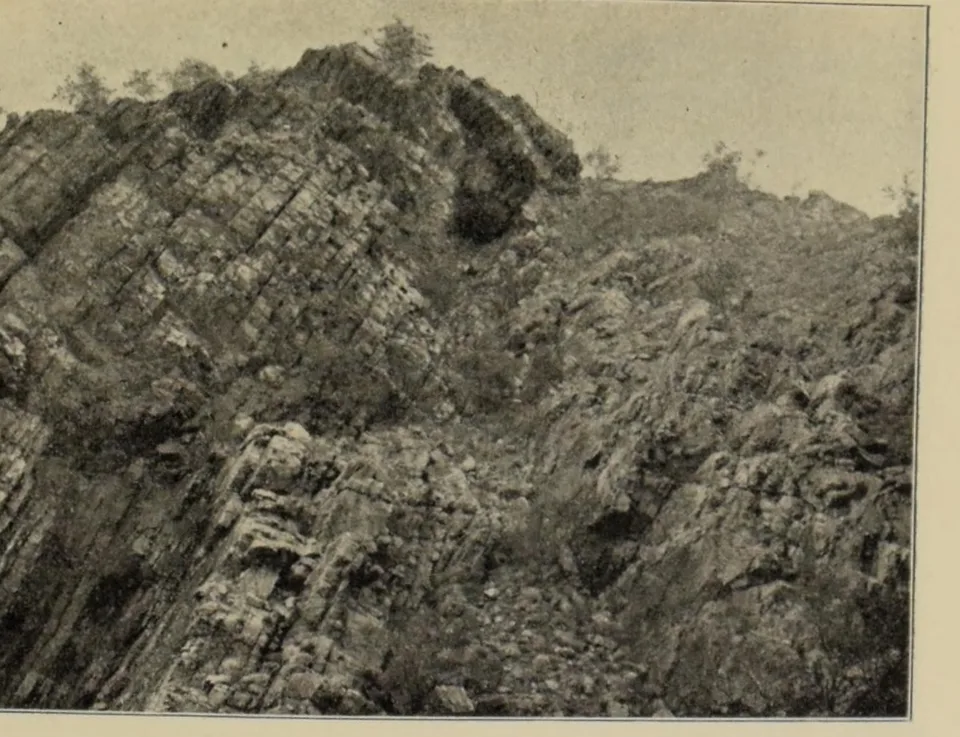 A steep, broken rock face rising against the sky at Emily Gap.