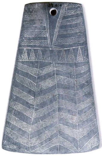 Trapezoidal engraved slate plaque with a single perforation at the top and banded chevron registers incised in white across its dark face.