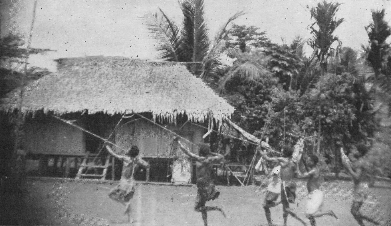 Bowmen leaping with raised bows in front of a thatched house on stilts, Bonggrang, 1953.