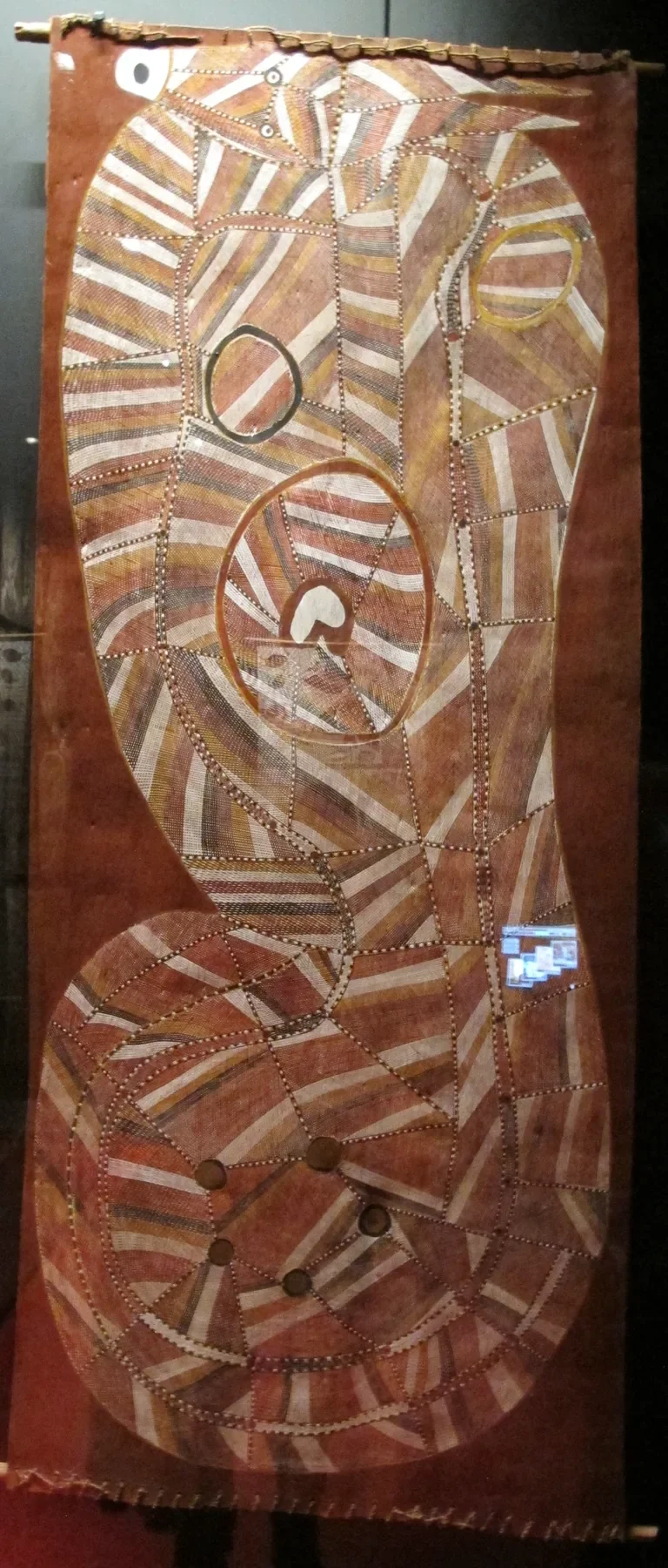 John Mawurndjul’s Ngaljod, a winding horned serpent whose body contains intricate red, white and ochre crosshatching.
