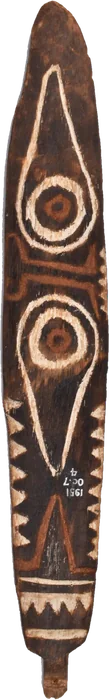 A long painted wooden bullroarer with paired concentric eye-like circles, angular white line patterns, and red and black bands.