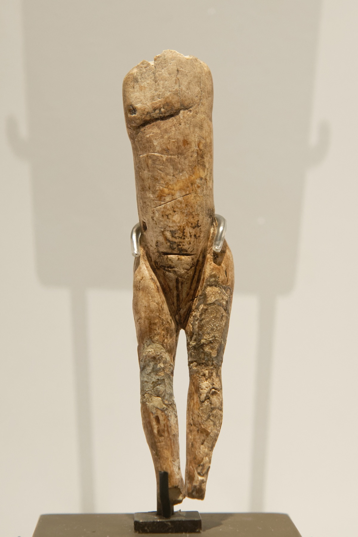 The long, slender mammoth-ivory female figure known as the Vénus impudique, displayed upright.