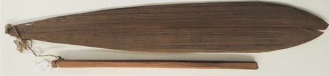 A Nuu-chah-nulth cedar bullroarer with a forked tip and a cord joining its narrow end to a straight stick handle below.