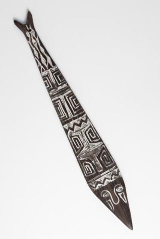 A dark, fish-tailed Marind bull-roarer blade, broad and pointed, pierced at one end for a cord.