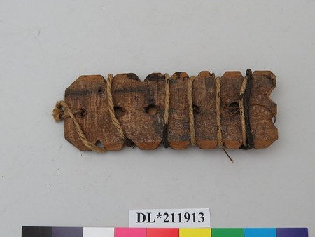 Several small notched, perforated boards from the Edward Lovett collection, strung together on a single cord: English folk bullroarers of the...