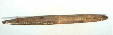 A zoemhout — "buzzing wood" — from Astrolabe Bay, its blade carved with a band of diamond and chevron ornament near the cord hole; a specimen...