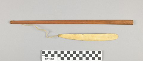 Point Barrow bone blade on sinew beside its wooden handle