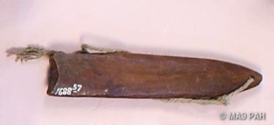 The wooden member of the same Bamana pair: a dark leaf-shaped ritual bullroarer collected by Leo Frobenius, with cord knotted through its end...