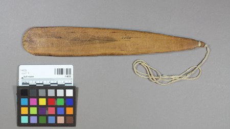 The Chukchansi (Yokuts) wimias itself, a plain double-pointed wooden board with a cord looped at one end, collected by A. L. Kroeber at...