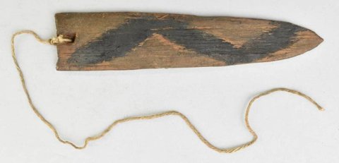 A Trumai blade from the Rio Culuene with a broad black zigzag painted across its brown wood, still tied to its cord.