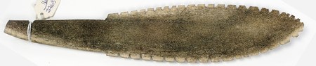The Mushuau Innu (Naskapi) serrated antler bull-roarer documented here, its teeth cut along both edges of the blade, cord wound at the tapered...