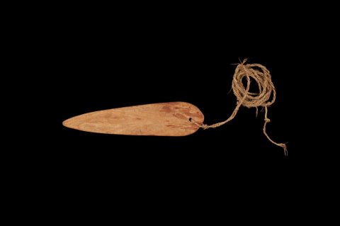 Uni, a Fali spearhead-shaped roarer on its bean-vine cord.