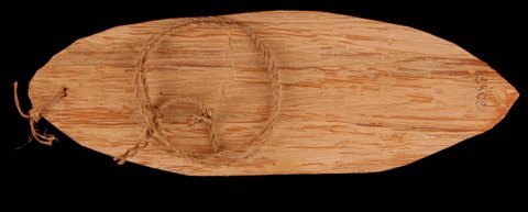 Mangisa Imbakiyam from Sa’a, Cameroon: a broad leaf-shaped wooden blade with fibre cord through one end and looping across its face.