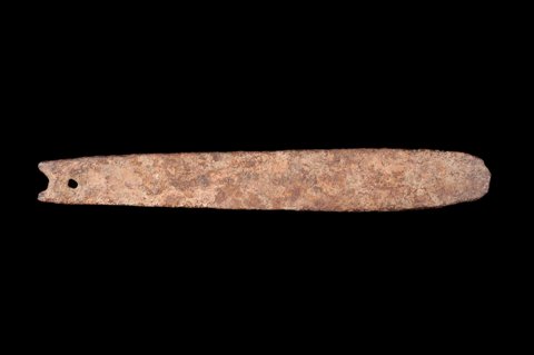 A long rough iron Koma rhombe with an irregular notched head and a round hole near that end.