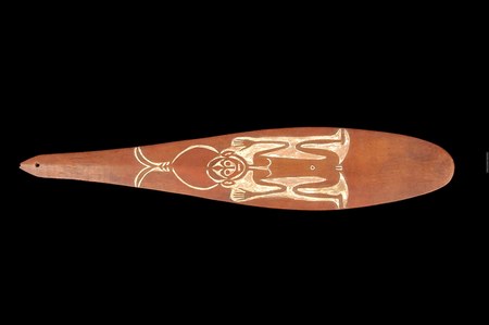 An elongated wooden blade with a smooth teardrop outline and a small perforation at the tip of its narrow tail — the Solos rhombe from Buka...