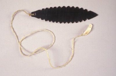 Iñupiaq baleen imigluktaaq from Wainwright: a dark, deeply serrated blade with a cord attached at one end and trailing in a loop below.