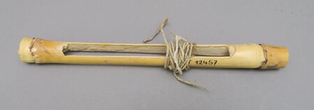 The Mafa specimen itself: a section of millet stalk split into two sounding tongues, with its long cotton cord coiled around the centre.