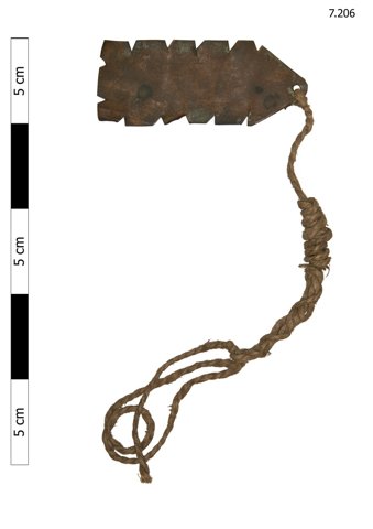 Otterbourne copper bullroarer in the Horniman Museum, with deep notches along both edges and a long looped cord attached through one end hole.