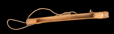 Kouroumba atongu from Yoro, Mali: a bamboo tube with a long rectangular side opening and cord trailing from one end.