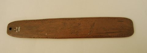 The plain reverse face, tool-marked, with the terminal cord hole.
