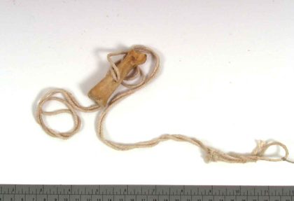 The Madla snorlebein — pig's foot-bone on its long cord.