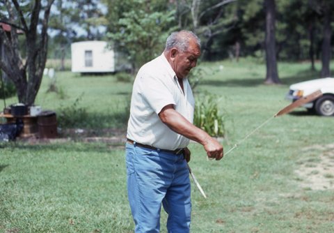 Bel Abbey spins a Koasati bullroarer at his home near Elton, Louisiana.