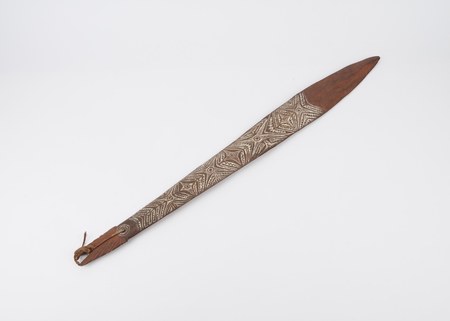 Carved Papuan Gulf bull-roarer, shark motif with lime-inlaid geometry — representative for the Moripi (Gulf). Science Museum Group A242490.