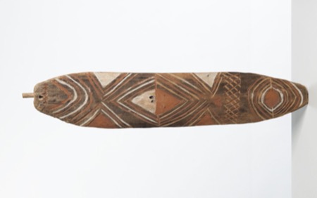 Kiwai bull-roarer from the mouth of the Fly River, collected by Gunnar Landtman in 1910–12: a flat board 57.5 cm long, carved with concentric...