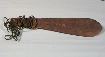 A paddle-shaped wooden Schwirrholz from Kalil village, its blade rounded rather than pointed, with plaited cord bound thickly around the...