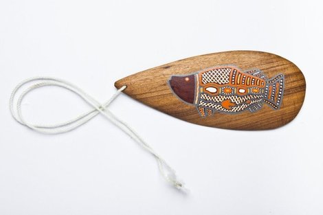 A wattle-wood board painted in the X-ray style with a polychrome fish, strung on a single cord — a Northeast Queensland piece of the general...