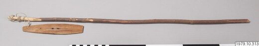 The Wéhnayey jwim-jwim itself, preserved as a complete rig: straight handle, long cord, and slim wooden blade.