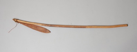 A long, gently curved stick fitted with a narrow wooden blade bound near one end with cord — a Southeast Asian bull-roarer held by the British...