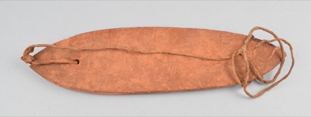 A smooth, reddish-brown oval board with a faint carved centerline and a cord threaded through a hole at one end — an African bull-roarer held...
