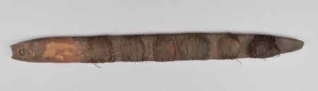 A wooden blade whose midsection is wound thickly in dark cord, with a further hank knotted at the tip — again a generic specimen, not the edila...