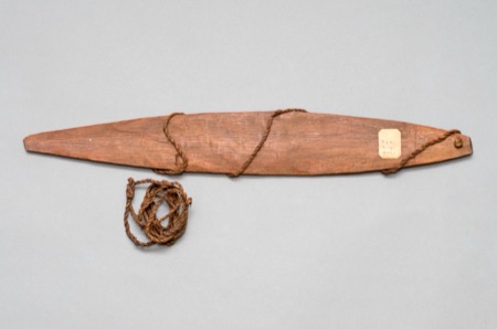 An oval wooden blade wound about with plant-fiber cord and marked with an old paper accession tag - a generic New Guinea bullroarer, not the...