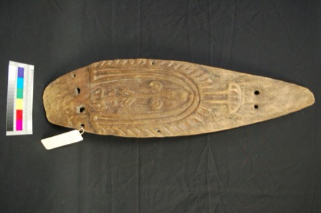 A ceremonial bull-roarer from Baramura on the Fly River, its petaloid board carved with a hooded anthropomorphic face, collected by Gunnar...