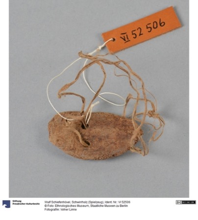 A small, weathered Eipo bull-roarer worn nearly smooth, its pierced end threaded with several twisted cords; not the Sulka vuvu documented here.