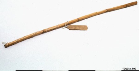 A Nahua bull-roarer of the stick-and-cord kind — a long slender cane, cord wound spirally along its shaft, a small flat wooden slip slung from...