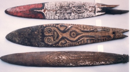 Another blade from the same Hospice Saint-Roch photograph, carved with a tan face motif and sunburst eye against a black ground; shown for the...