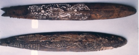 Another photograph from the Hospice Saint-Roch group — two dark bull-roarer blades side by side, the upper fork-tailed with white-filled...