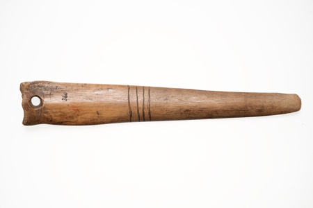 The smoothed front of the Ruin 14 bone blade itself: a deer metapodial tapering from a squared-off wide end to a rounded tip, with a single...