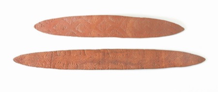 A wooden board carved in a diamond chevron pattern — a generic Aboriginal Australian piece, not the boorbing or the long yeenma boards incised...