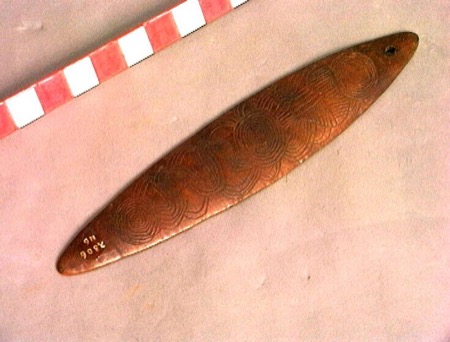 A board carved with tightly clustered concentric circles along its length — an Aboriginal Australian bull-roarer held by the Wereldmuseum,...