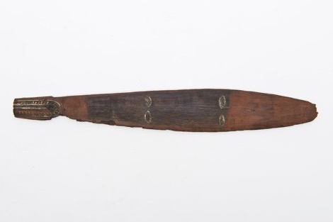 A lanceolate Astrolabe Bay bull-roarer, its narrow tang carved with white-infilled sawtooth ridges around the cord hole and four small...