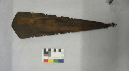 A wood blade shaped like a spearhead, its narrow end bound in twisted cord — again a Naga instrument shown for the general South Asian type,...