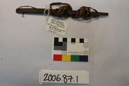 The Upper Watut bullroarer 2006.87.1 with its bark-fibre cord and Blackwood's 1937 tag.