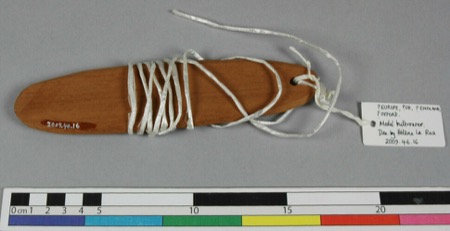 A model bullroarer at the Pitt Rivers Museum — an oval wooden board wound with plastic cord — used only to represent the general form; Gregor's...