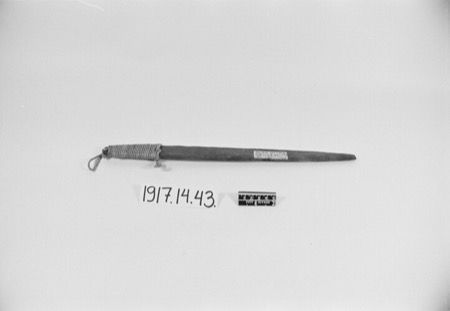 A tapering wooden slat bull-roarer with cord wound at the broad end, collected from the Egba of southwestern Nigeria; the Senufo rhombes played...