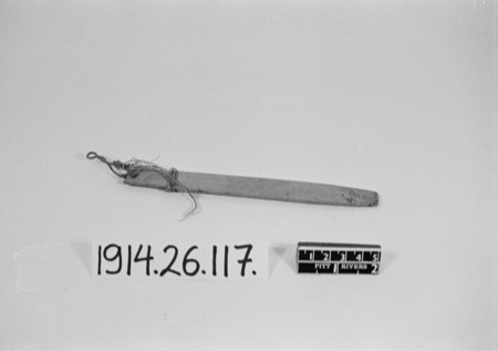 A long flat wooden blade with cord bound near one end, again an Ejagham piece shown for the general African form — not the blackened,...