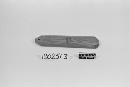 A plain wooden English bull-roarer tapering to a perforated tip for the cord; the eroded, perforated bison rib recovered from Pin Hole Cave at...